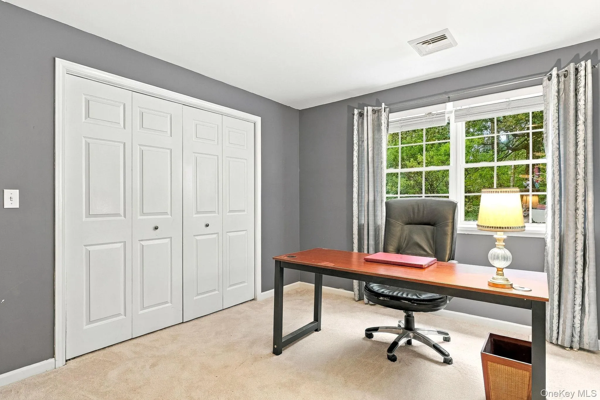 Double-panel closet doors, two large windows, wall-to-wall carpeting, and neutral wall paint Double-panel closet doors, two large windows, wall-to-wall carpeting, and neutral wall paint