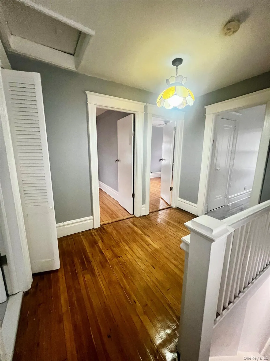 Corridor with attic access, hardwood / wood-style flooring, and an upstairs landing Corridor with attic access, hardwood / wood-style flooring, and an upstairs landing