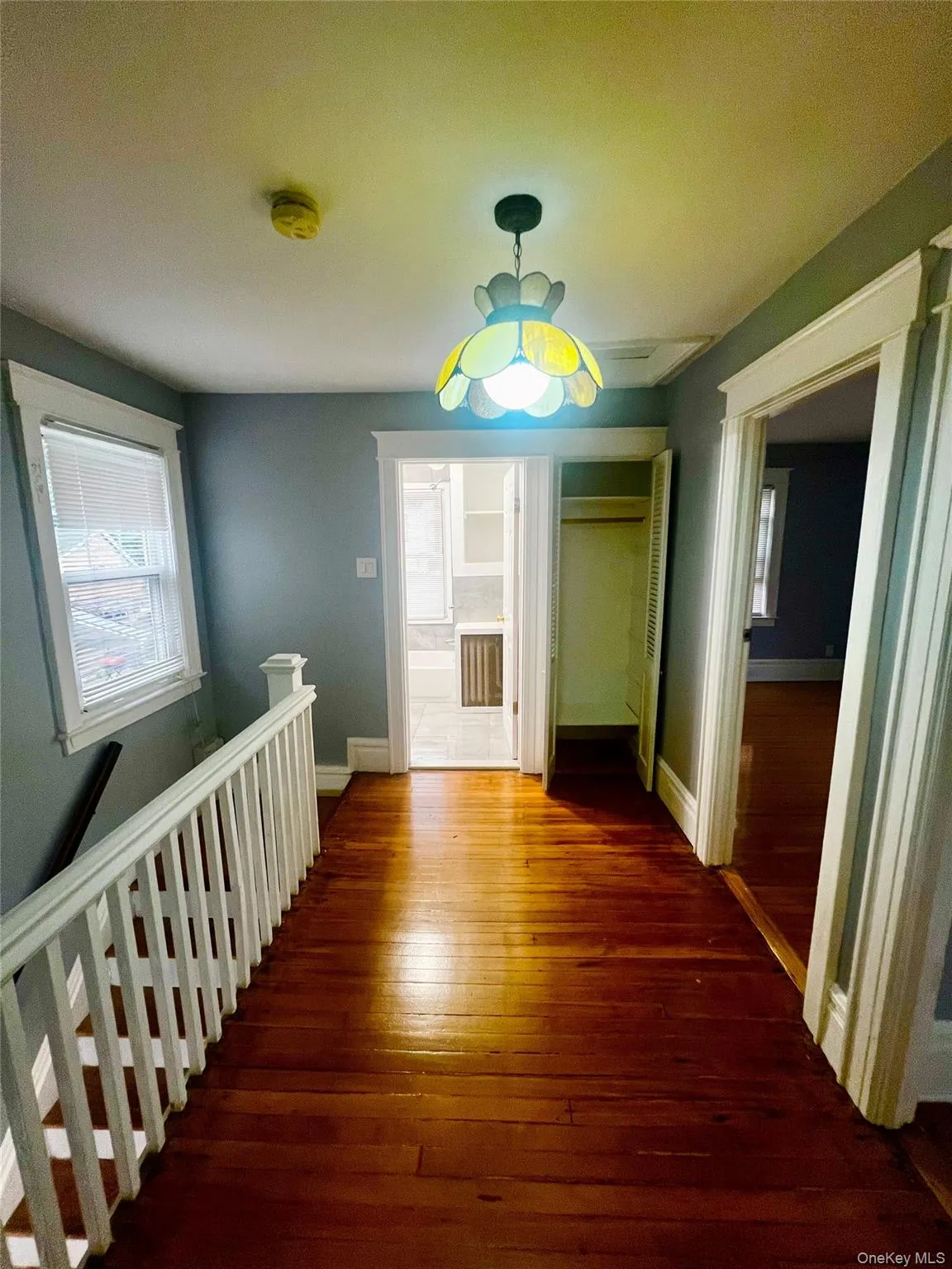 Hallway with hardwood / wood-style flooring and an upstairs landing Hallway with hardwood / wood-style flooring and an upstairs landing