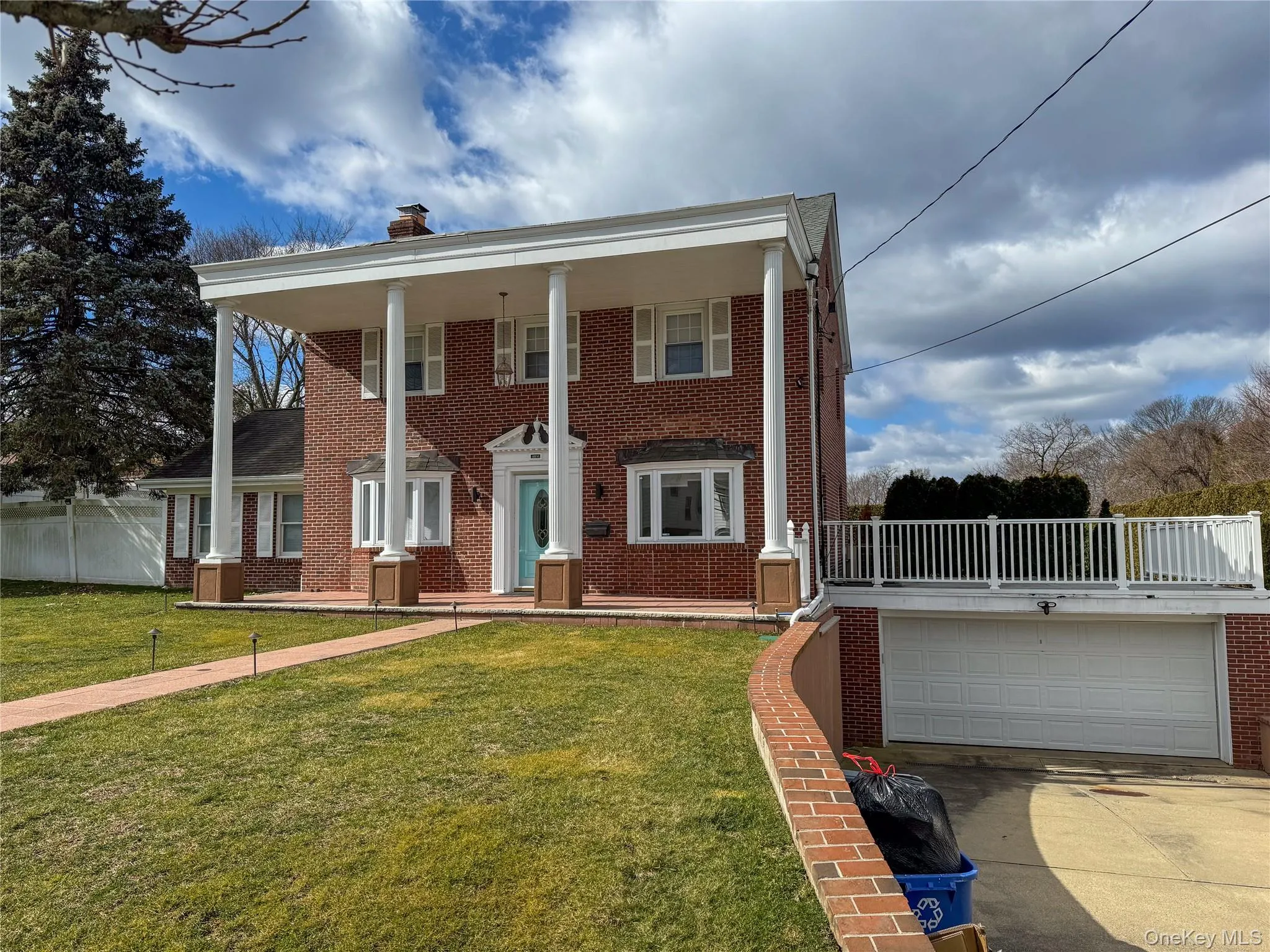 Brick exterior with a prominent portico featuring round columns, 2 car garage Brick exterior with a prominent portico featuring round columns, 2 car garage