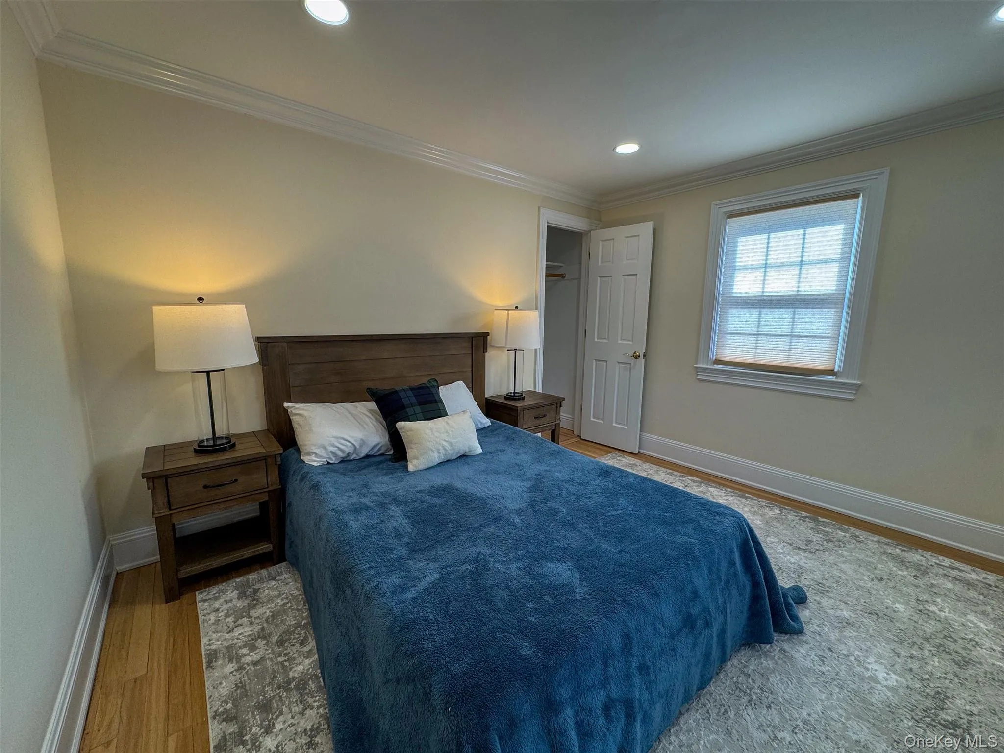 Wood-finish flooring, recessed lighting, crown molding, double-pane window, and a built-in closet Wood-finish flooring, recessed lighting, crown molding, double-pane window, and a built-in closet