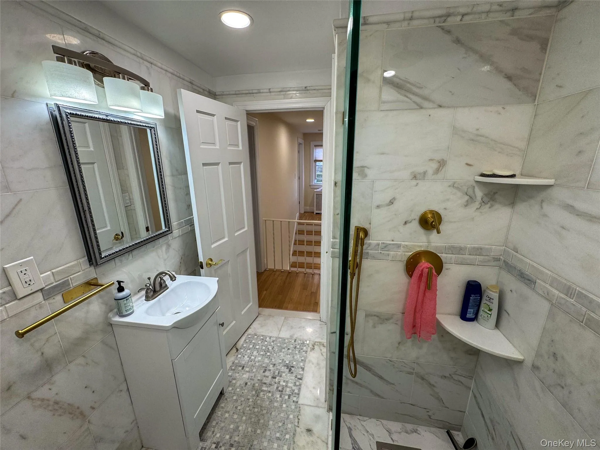Shower with full-height tile surround, brass fixtures, and built-in shelving Shower with full-height tile surround, brass fixtures, and built-in shelving