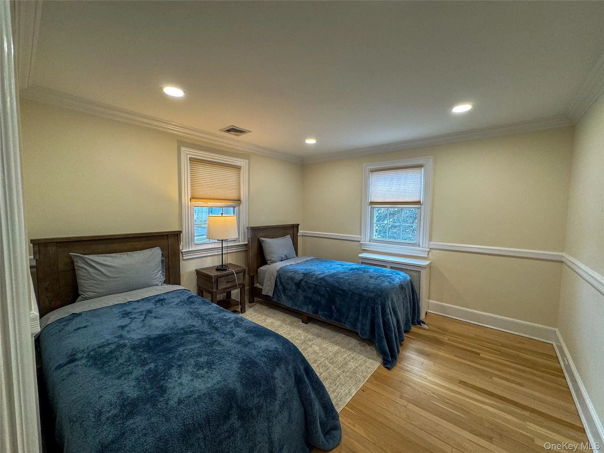 Recessed ceiling lighting, crown molding, wood-finish flooring, two windows with blinds, and wainscoting Recessed ceiling lighting, crown molding, wood-finish flooring, two windows with blinds, and wainscoting
