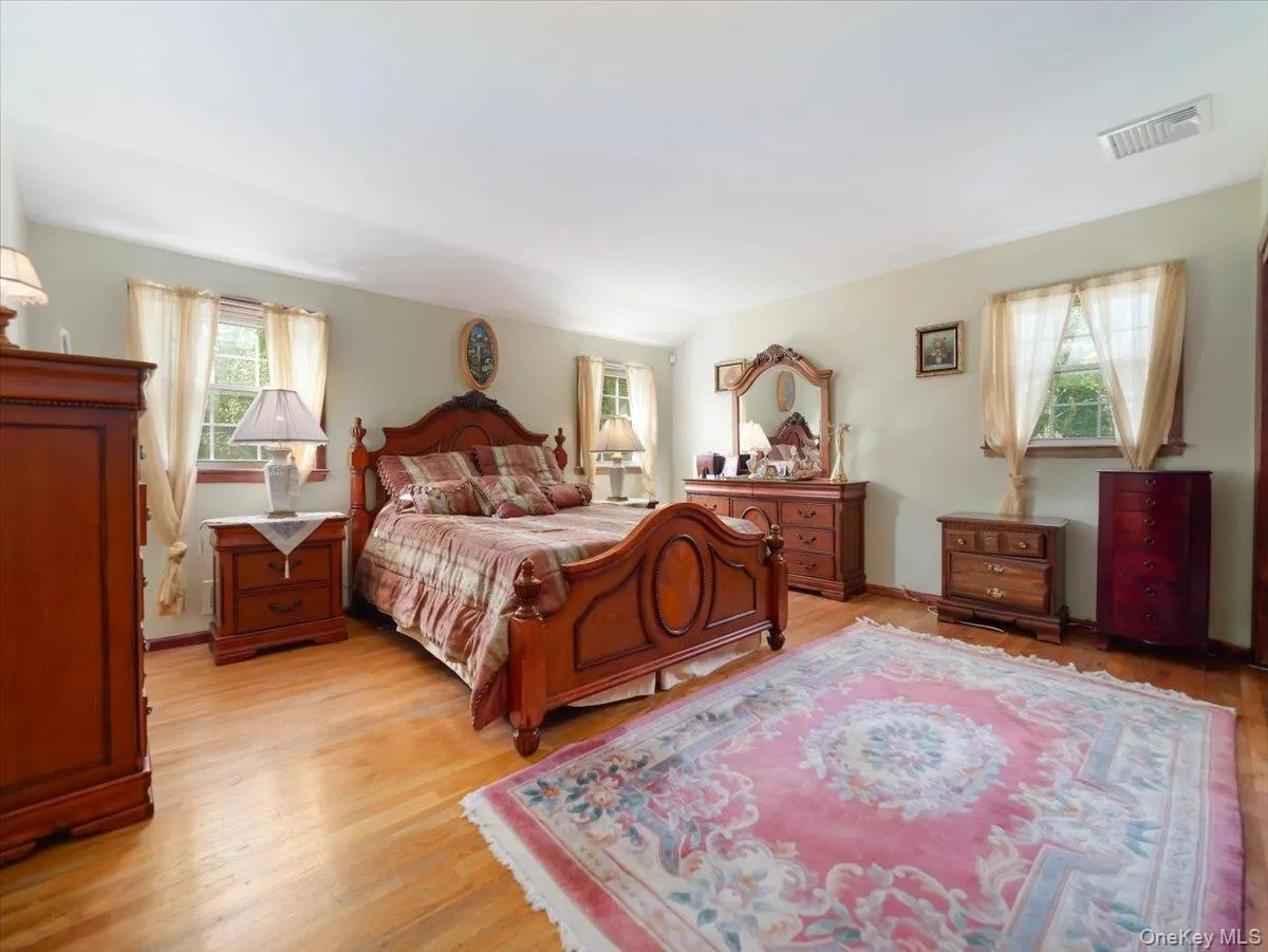 Expansive room featuring wood-finish flooring, neutral wall paint, and multiple windows with exterior exposure Expansive room featuring wood-finish flooring, neutral wall paint, and multiple windows with exterior exposure