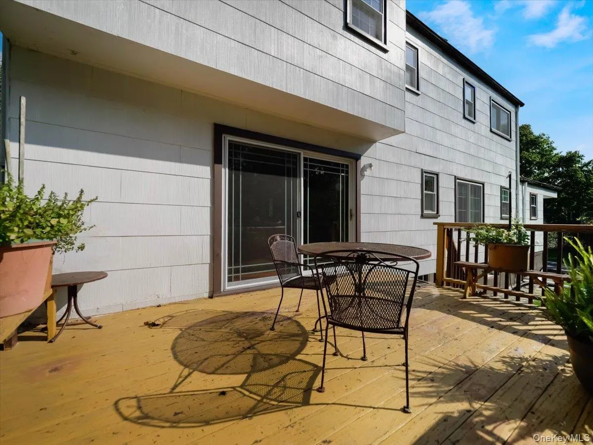 Rear wood deck featuring an attached wood railing and a sliding glass door Rear wood deck featuring an attached wood railing and a sliding glass door