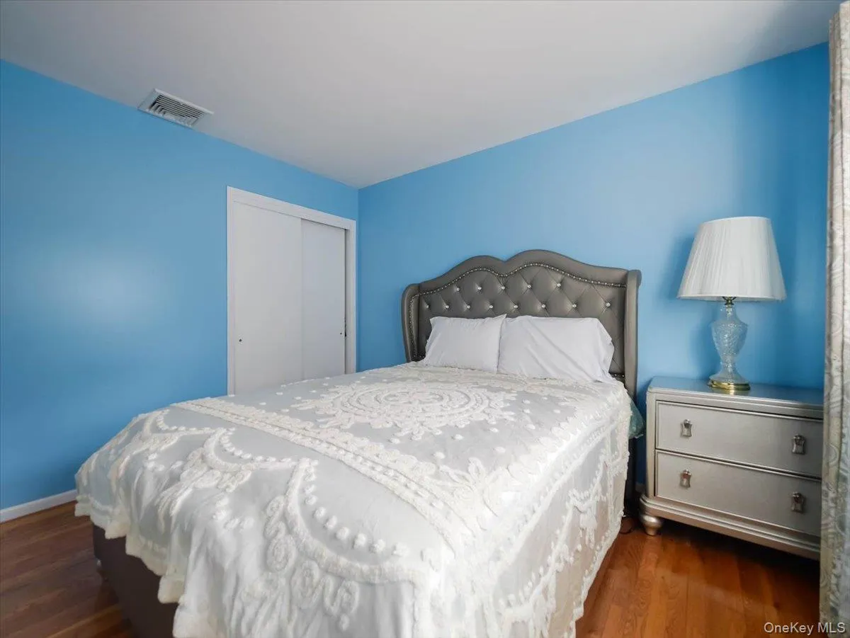 Bedroom featuring wood-finish flooring and a sliding door closet Bedroom featuring wood-finish flooring and a sliding door closet
