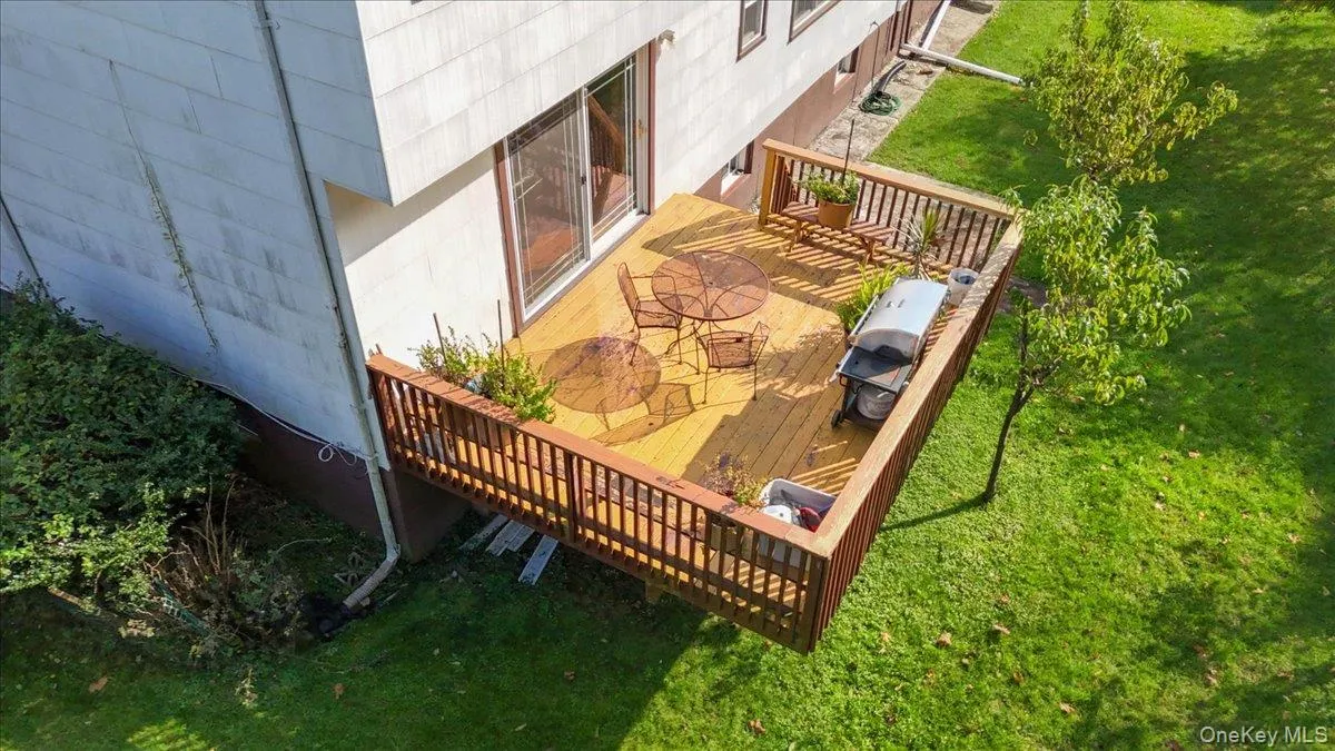 Elevated wood deck featuring vertical balustrade railings and sliding glass door access Elevated wood deck featuring vertical balustrade railings and sliding glass door access