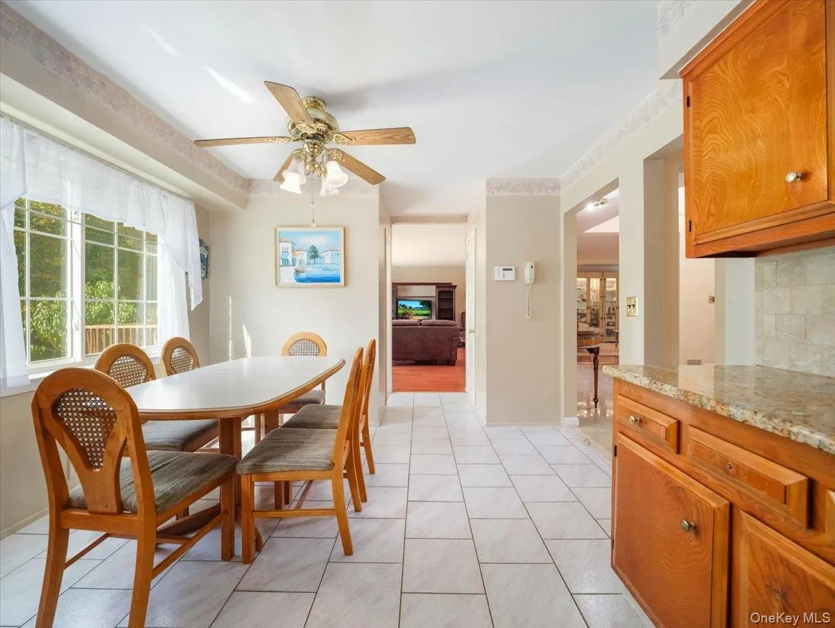 Dining area featuring tile flooring, a multi-light ceiling fan, and natural light from large windows Dining area featuring tile flooring, a multi-light ceiling fan, and natural light from large windows