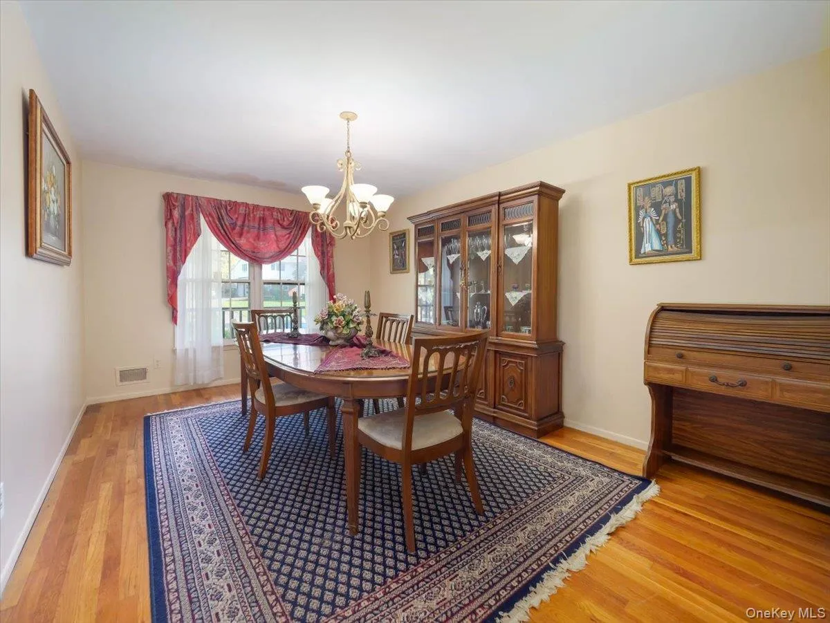 Formal dining area featuring wood-finish flooring and a multi-arm chandelier Formal dining area featuring wood-finish flooring and a multi-arm chandelier