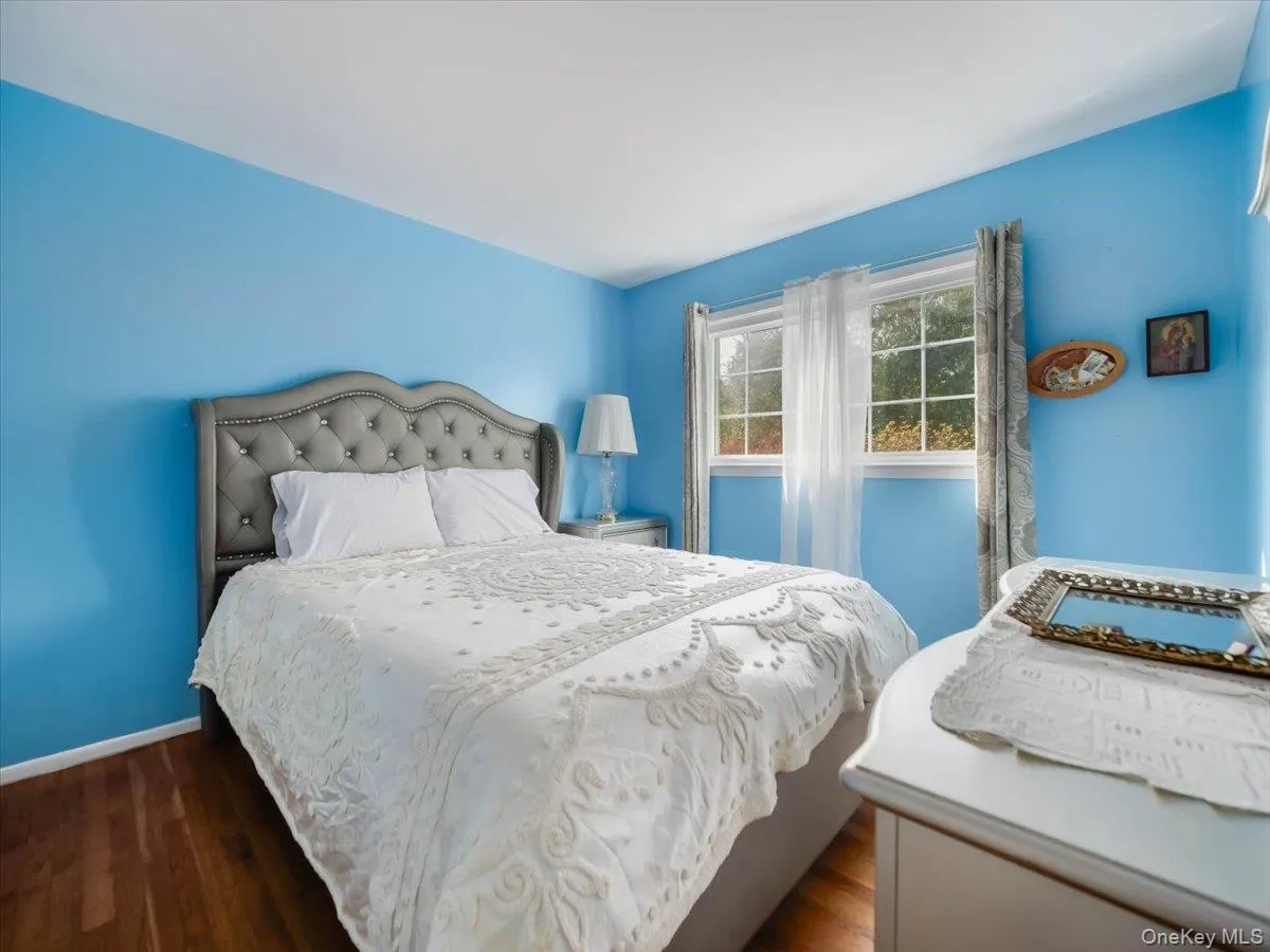 Room featuring wood-finish flooring and a multi-pane window with natural light Room featuring wood-finish flooring and a multi-pane window with natural light