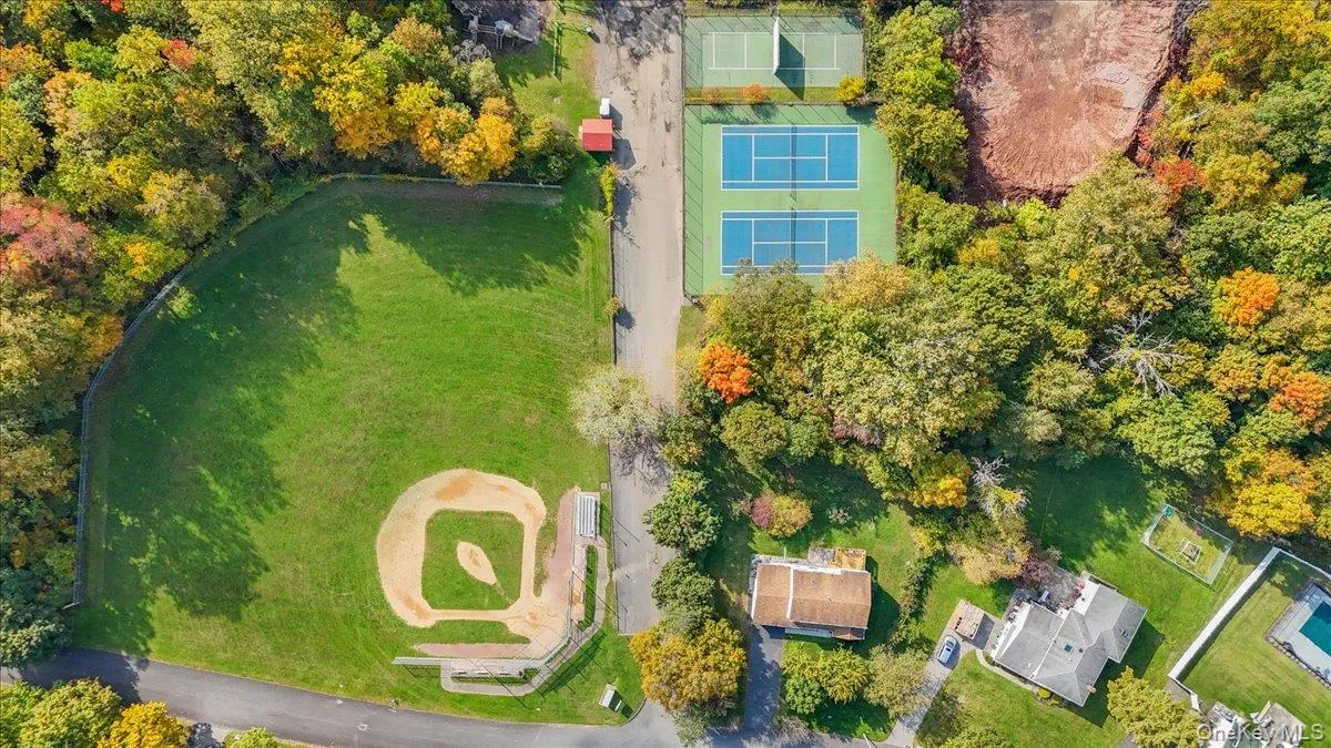Aerial perspective featuring two dedicated tennis courts and a baseball field with a grass infield Aerial perspective featuring two dedicated tennis courts and a baseball field with a grass infield