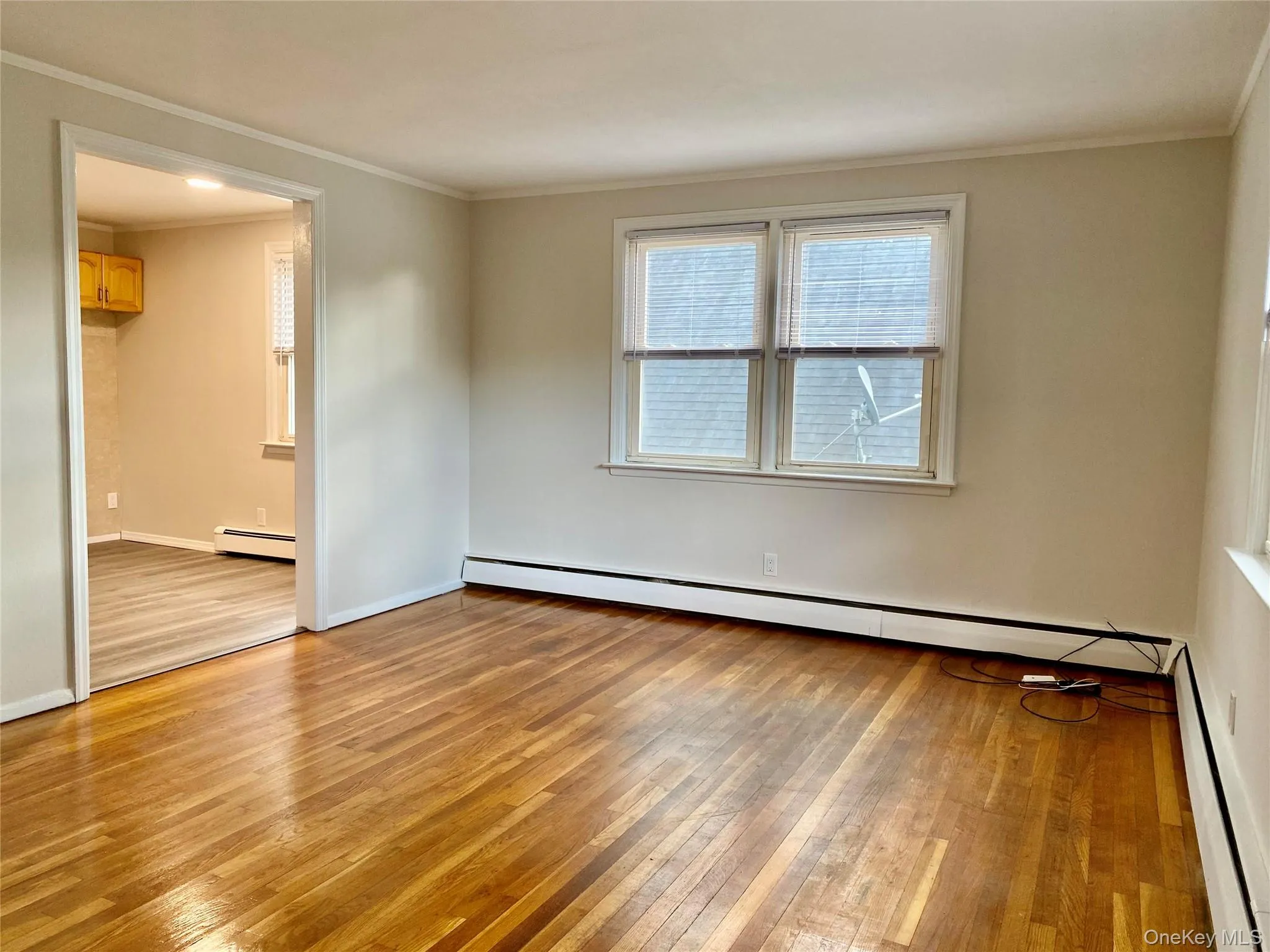 Hardwood flooring, neutral wall paint, white trim, and two windows with blinds Hardwood flooring, neutral wall paint, white trim, and two windows with blinds