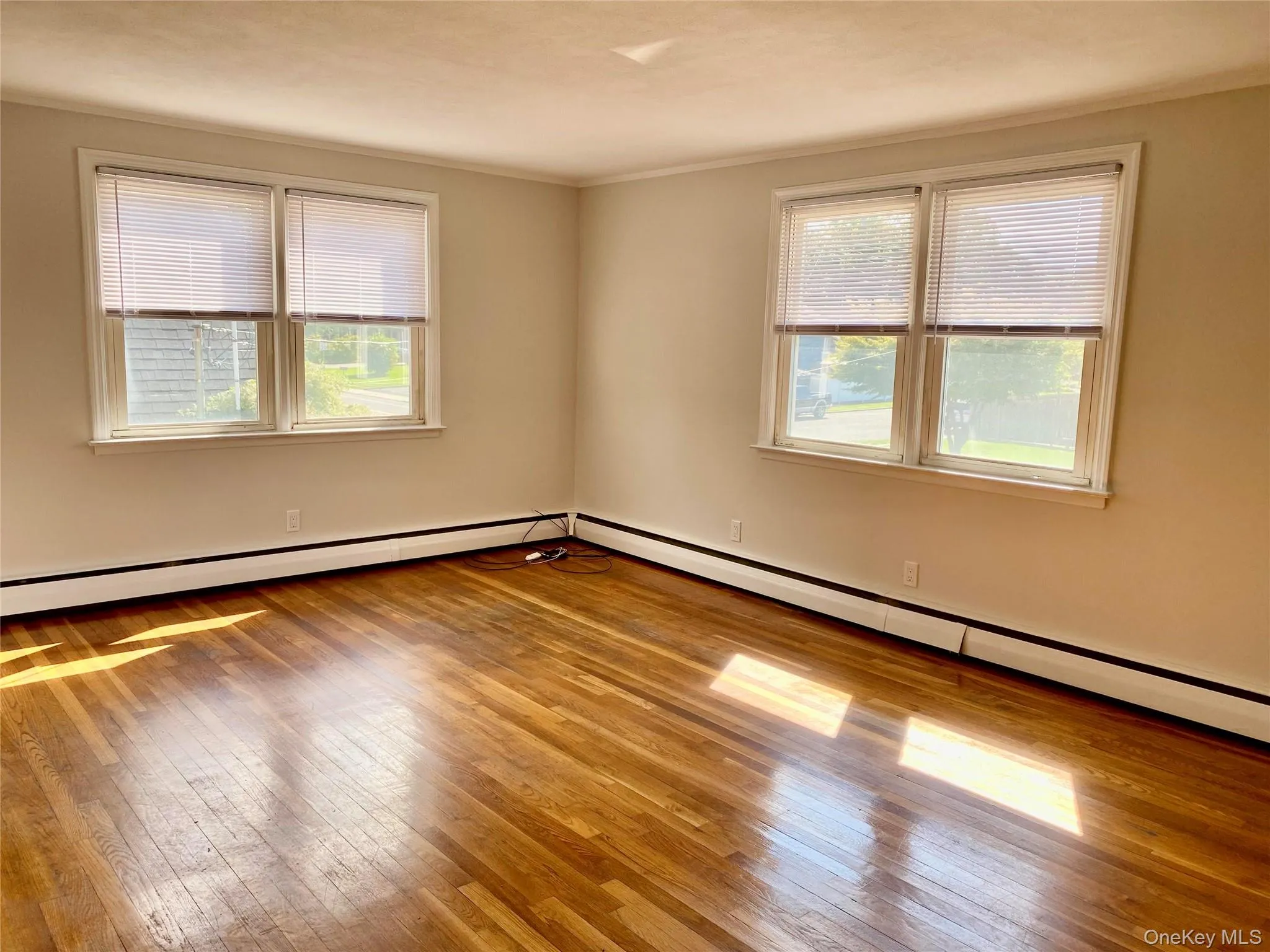 Hardwood flooring throughout, featuring two double-pane windows, and a neutral color palette Hardwood flooring throughout, featuring two double-pane windows, and a neutral color palette