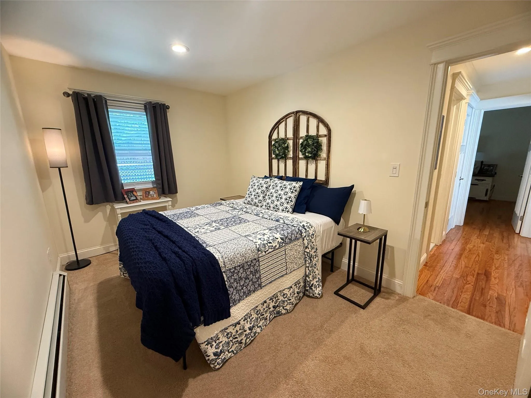 Carpeted bedroom with a baseboard radiator and recessed lighting Carpeted bedroom with a baseboard radiator and recessed lighting