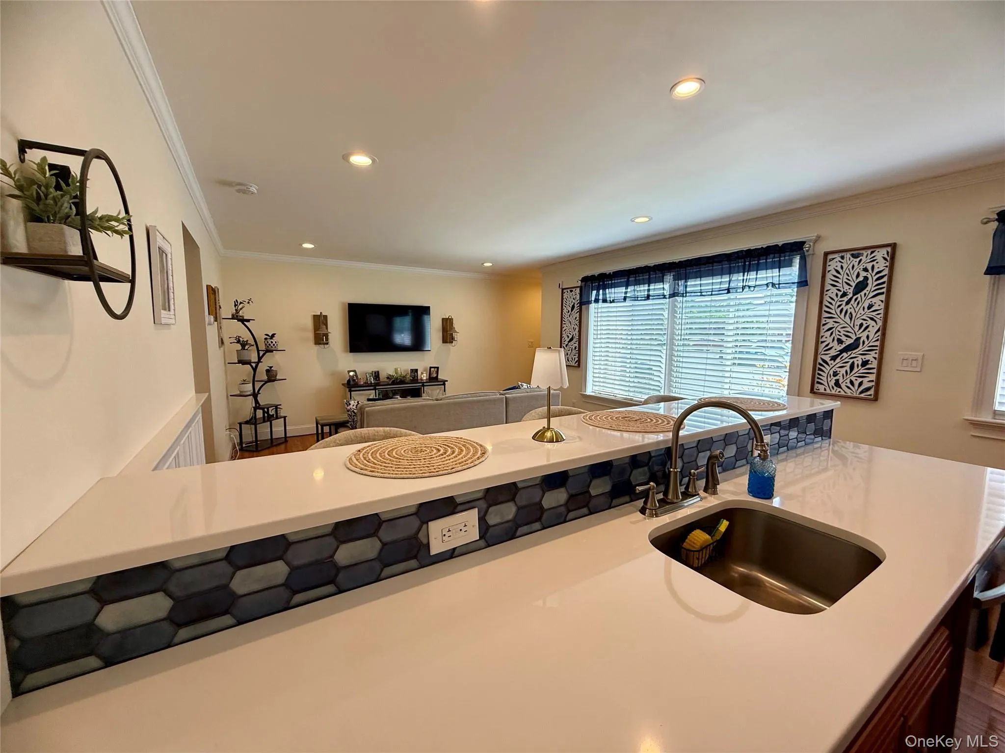 Kitchen featuring crown molding, recessed lighting, open floor plan, and light countertops Kitchen featuring crown molding, recessed lighting, open floor plan, and light countertops