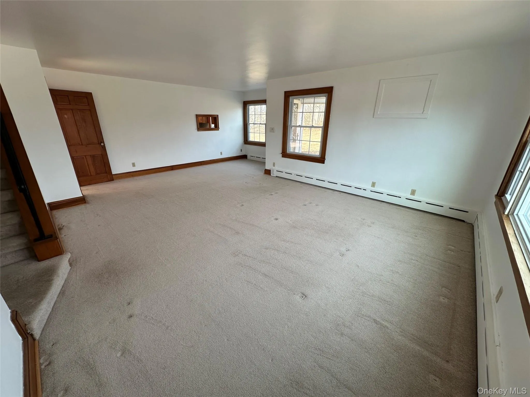Carpeted empty room with a baseboard heating unit and baseboards Carpeted empty room with a baseboard heating unit and baseboards