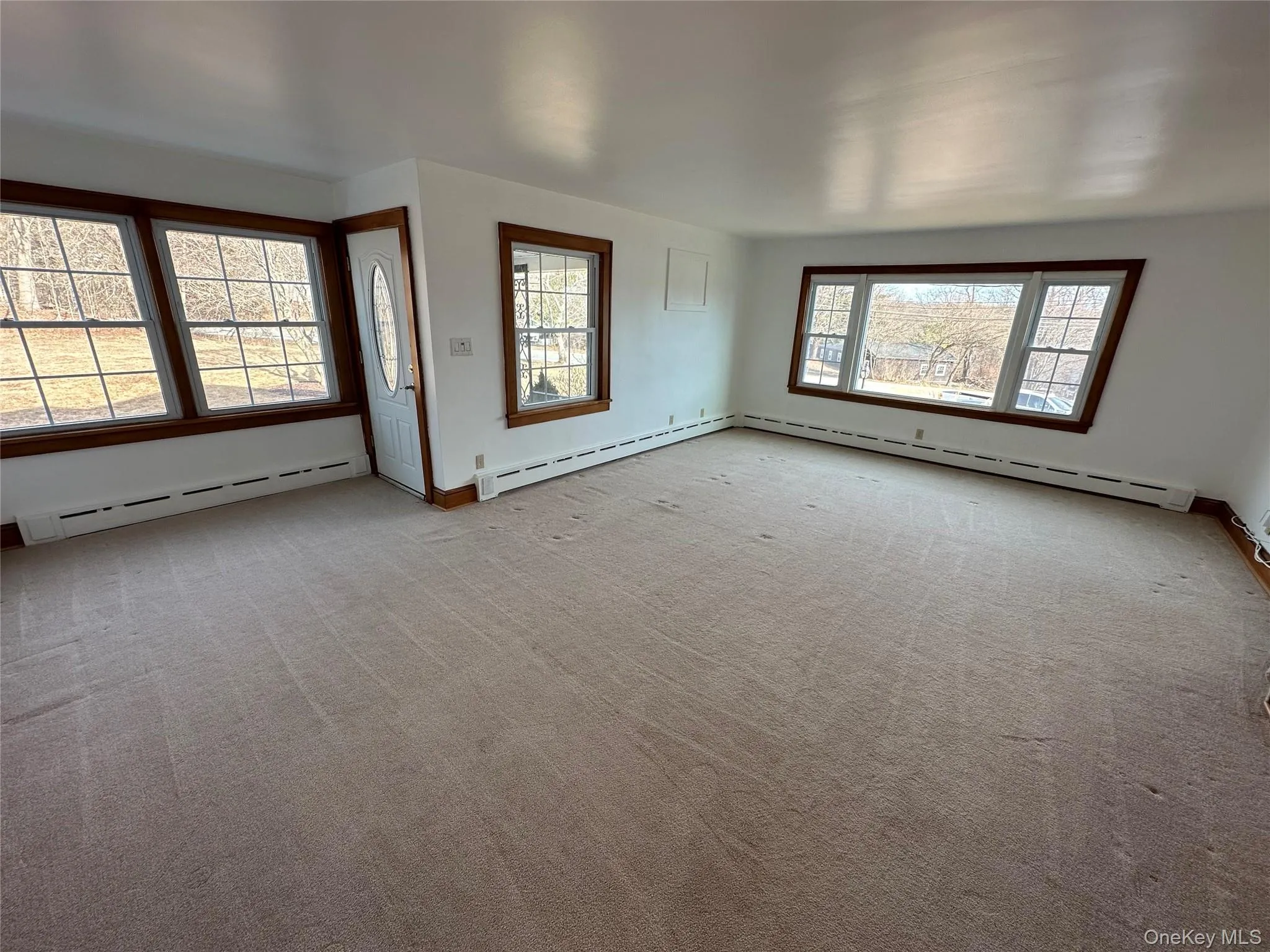 Carpeted empty room with a baseboard radiator Carpeted empty room with a baseboard radiator
