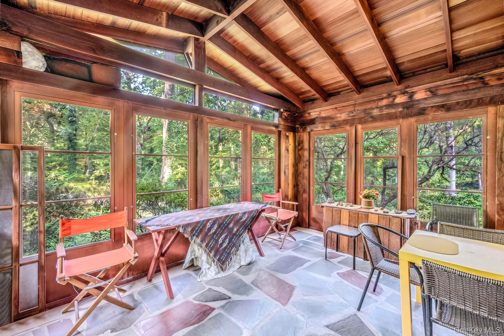 Sunroom with slate floor overlooking the beautiful wooded lot Sunroom with slate floor overlooking the beautiful wooded lot