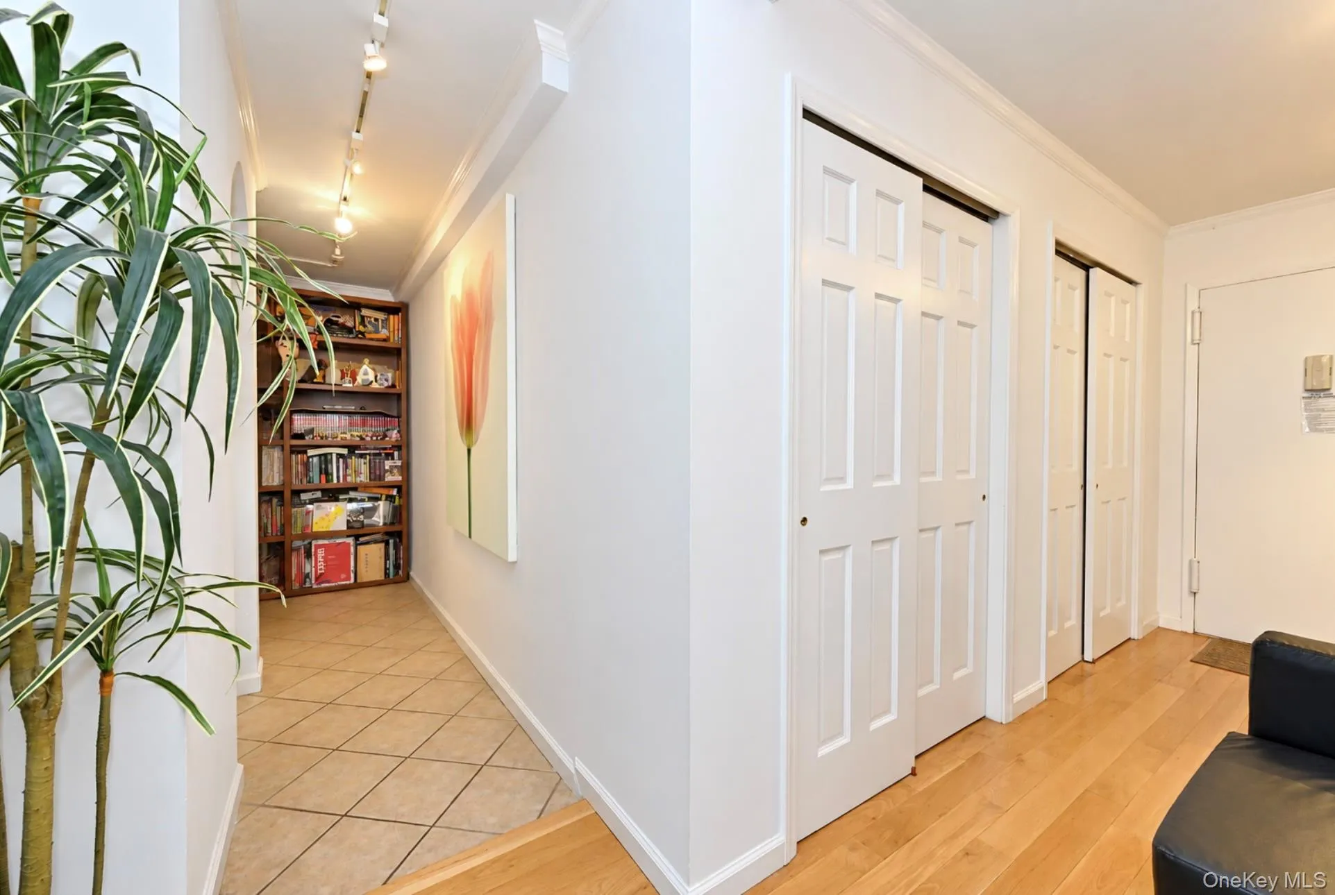 Hallway with light wood-finish flooring transitioning to diagonal tile Hallway with light wood-finish flooring transitioning to diagonal tile