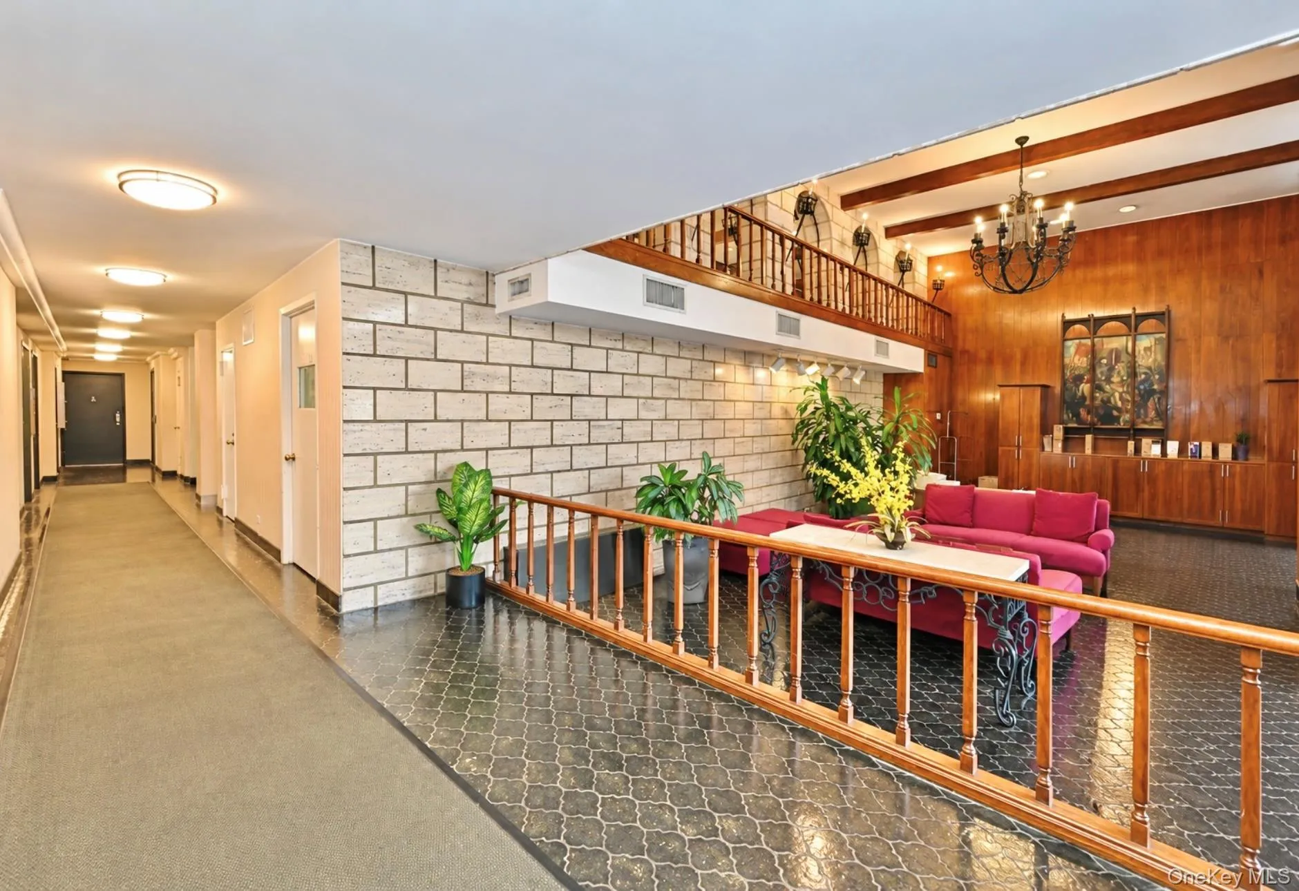 Two-story entry foyer featuring wood-finish paneling, a chandelier, and exposed ceiling beams Two-story entry foyer featuring wood-finish paneling, a chandelier, and exposed ceiling beams