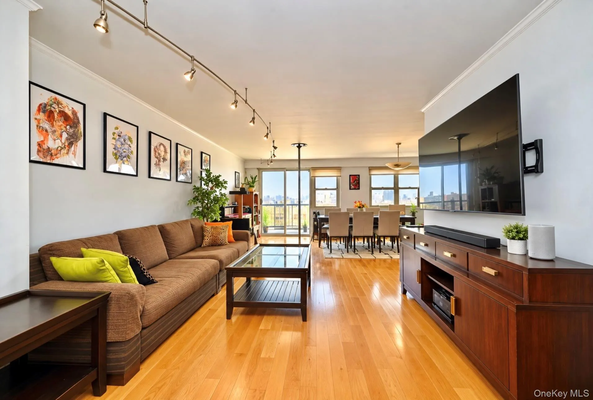 Hardwood flooring, track lighting, and a wall-mounted entertainment console Hardwood flooring, track lighting, and a wall-mounted entertainment console