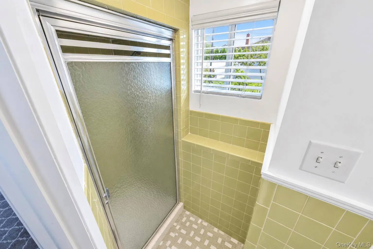 Shower enclosure with textured glass panel, chrome-finish framing, and tile surround Shower enclosure with textured glass panel, chrome-finish framing, and tile surround