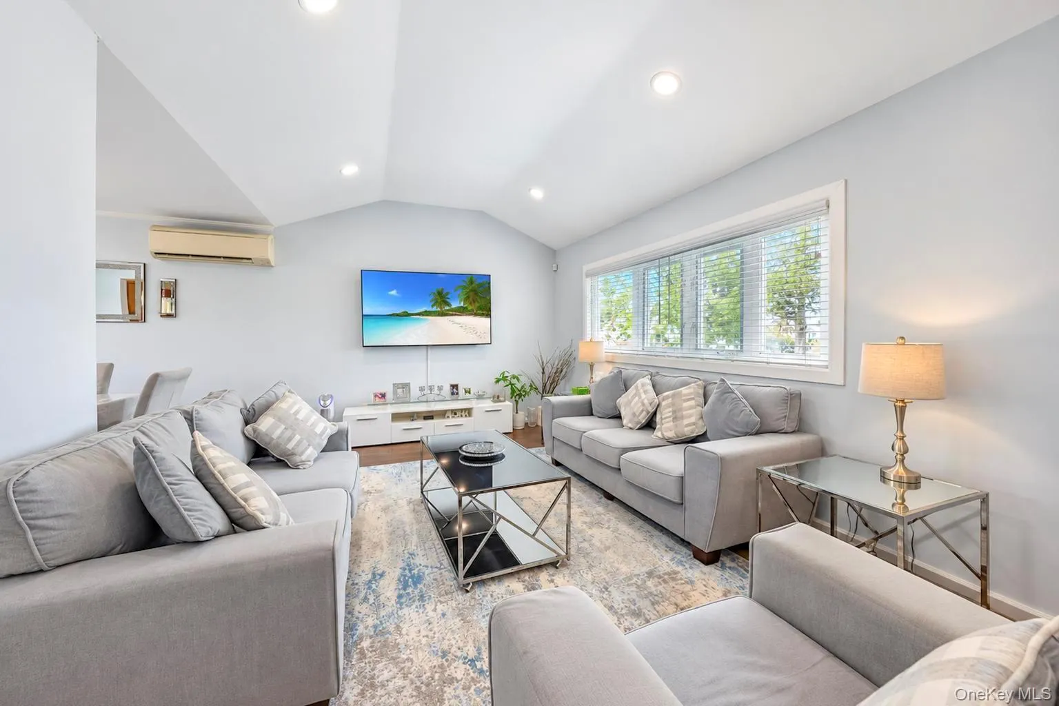 Vaulted ceilings, recessed lighting, and a wide window with blinds Vaulted ceilings, recessed lighting, and a wide window with blinds