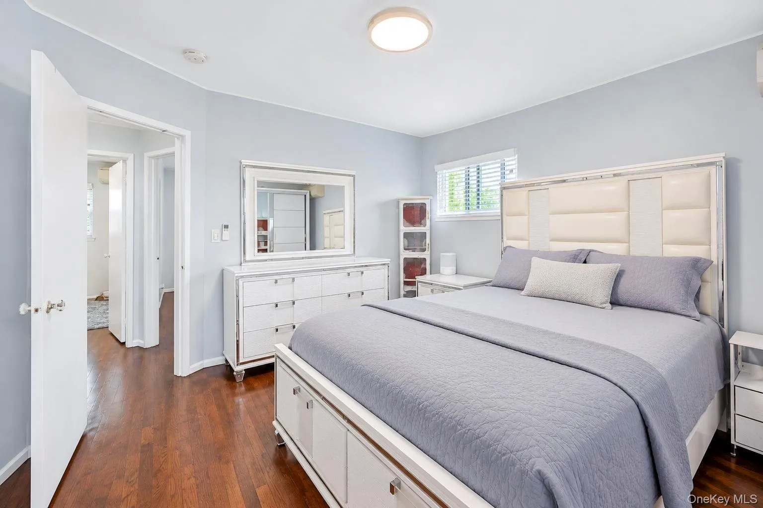 Rich wood-finish flooring, light blue walls, and a window with blinds provide natural illumination Rich wood-finish flooring, light blue walls, and a window with blinds provide natural illumination