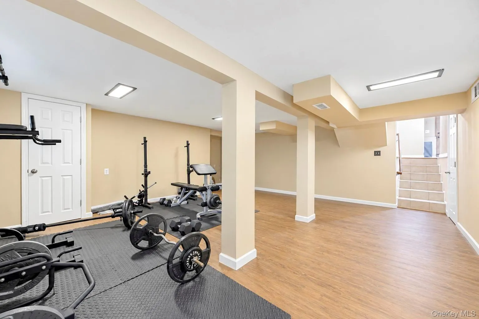 Expansive finished lower level featuring wood-finish flooring, recessed lighting, and a neutral color palette Expansive finished lower level featuring wood-finish flooring, recessed lighting, and a neutral color palette