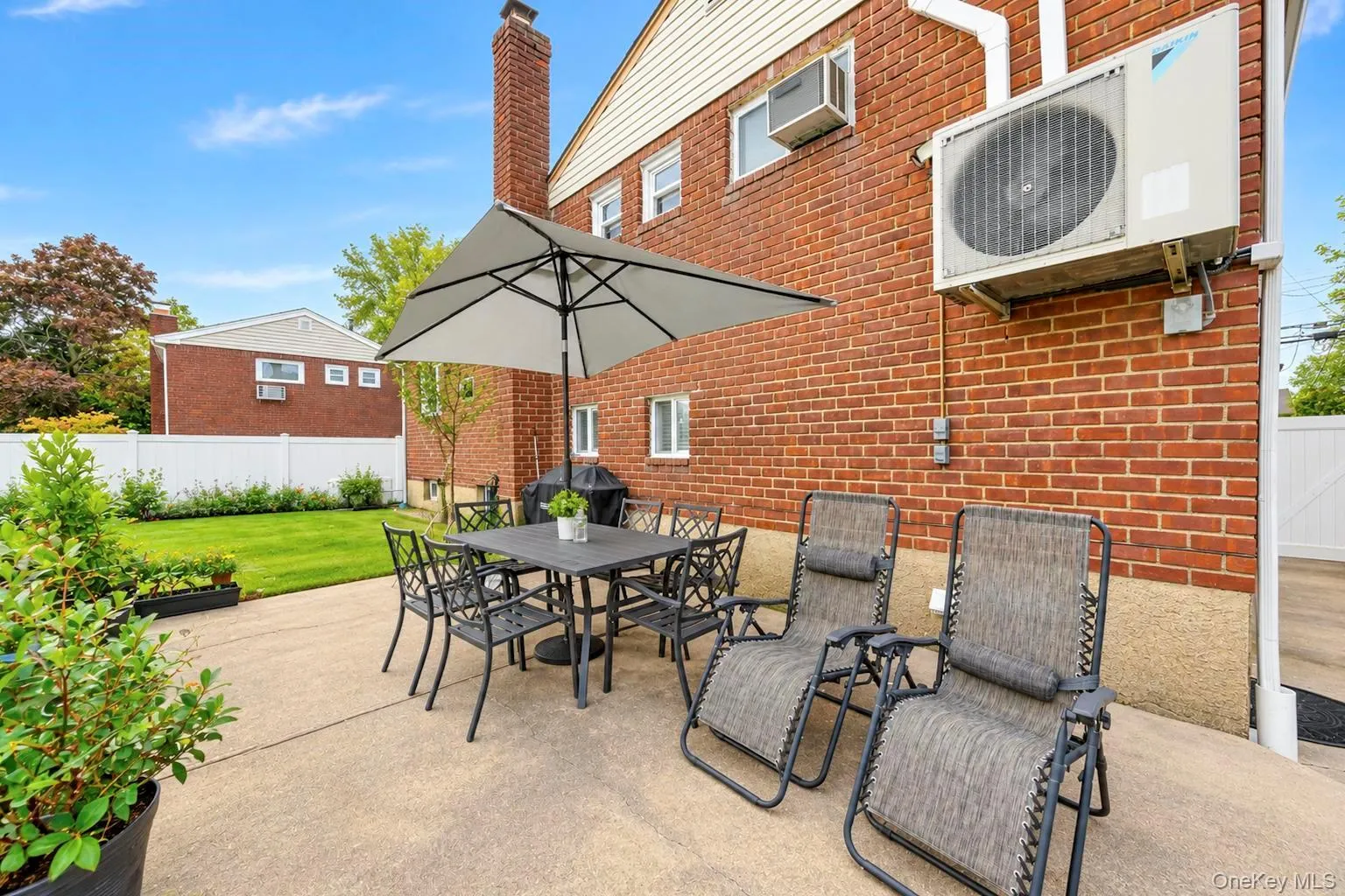 Patio area featuring a concrete surface, manicured lawn, and privacy fencing Patio area featuring a concrete surface, manicured lawn, and privacy fencing