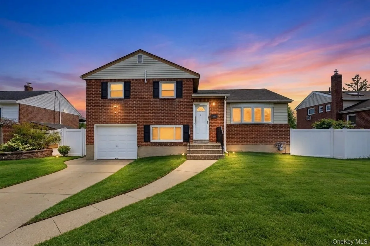 Brick exterior with siding accents, attached garage, concrete driveway, front lawn, and privacy fencing Brick exterior with siding accents, attached garage, concrete driveway, front lawn, and privacy fencing