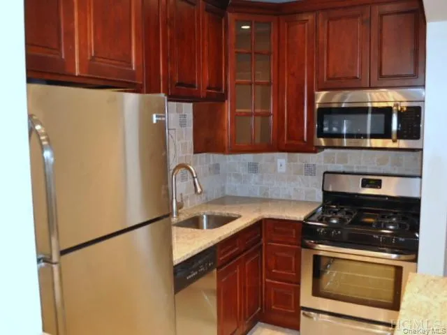 New Kitchen with Granite Counters, Stainless Steel Appliances, Cherry Cabinets and tumble tile back splash. The kitchen is open to the living room allowing plenty of light. New Kitchen with Granite Counters, Stainless Steel Appliances, Cherry Cabinets and tumble tile back splash. The kitchen is open to the living room allowing plenty of light.
