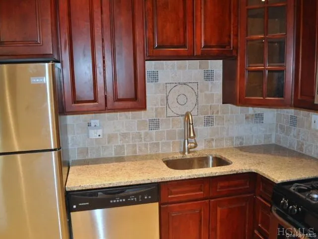 New Kitchen with Granite Counters, Stainless Steel Appliances, Cherry Cabinets and tumble tile back splash. The kitchen is open to the living room allowing plenty of light. New Kitchen with Granite Counters, Stainless Steel Appliances, Cherry Cabinets and tumble tile back splash. The kitchen is open to the living room allowing plenty of light.