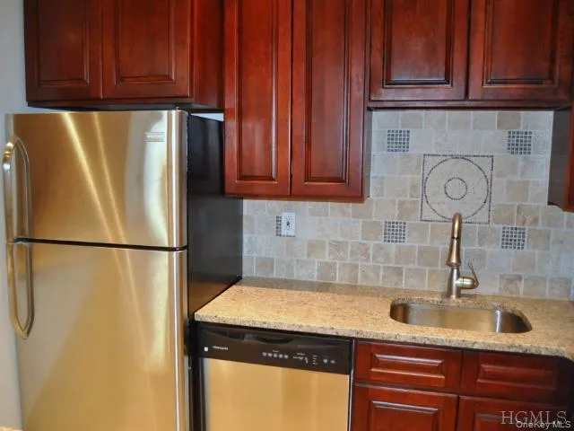 New Kitchen with Granite Counters, Stainless Steel Appliances, Cherry Cabinets and tumble tile back splash. The kitchen is open to the living room allowing plenty of light. New Kitchen with Granite Counters, Stainless Steel Appliances, Cherry Cabinets and tumble tile back splash. The kitchen is open to the living room allowing plenty of light.