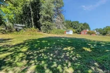 Expansive grassy lawn with mature trees and a detached shed Expansive grassy lawn with mature trees and a detached shed