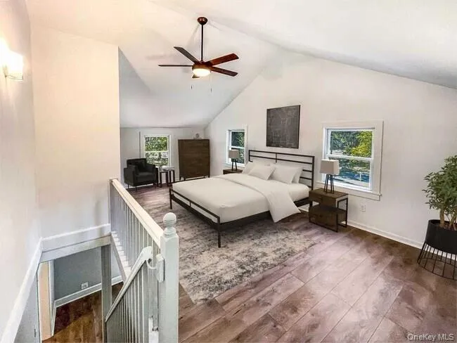 Vaulted ceiling with a ceiling fan, recessed wall lighting, wood-finish flooring, and white painted balusters Vaulted ceiling with a ceiling fan, recessed wall lighting, wood-finish flooring, and white painted balusters