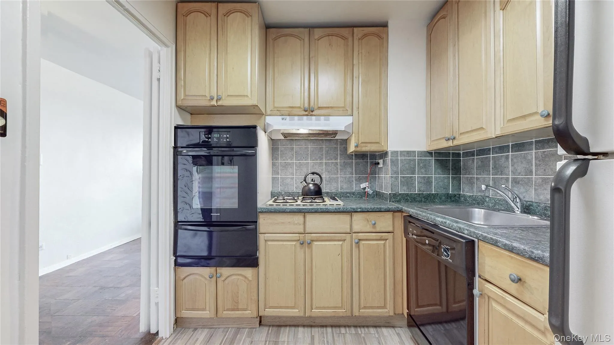 Kitchen featuring wood-finish cabinetry, built-in double oven, gas cooktop, dishwasher, and a stainless steel sink Kitchen featuring wood-finish cabinetry, built-in double oven, gas cooktop, dishwasher, and a stainless steel sink