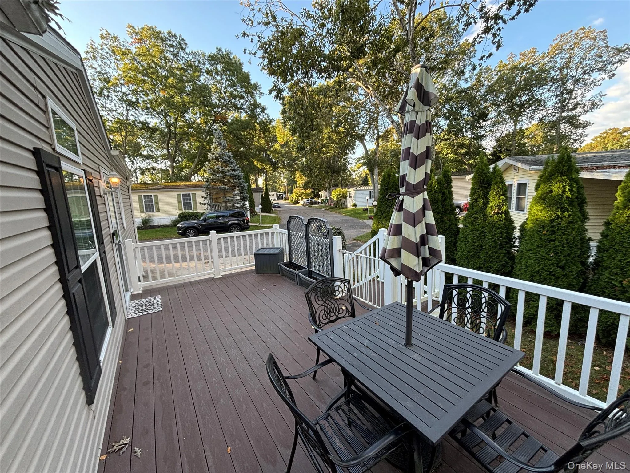 Expansive outdoor deck featuring wood-finish flooring, white railing, and exterior wall siding Expansive outdoor deck featuring wood-finish flooring, white railing, and exterior wall siding