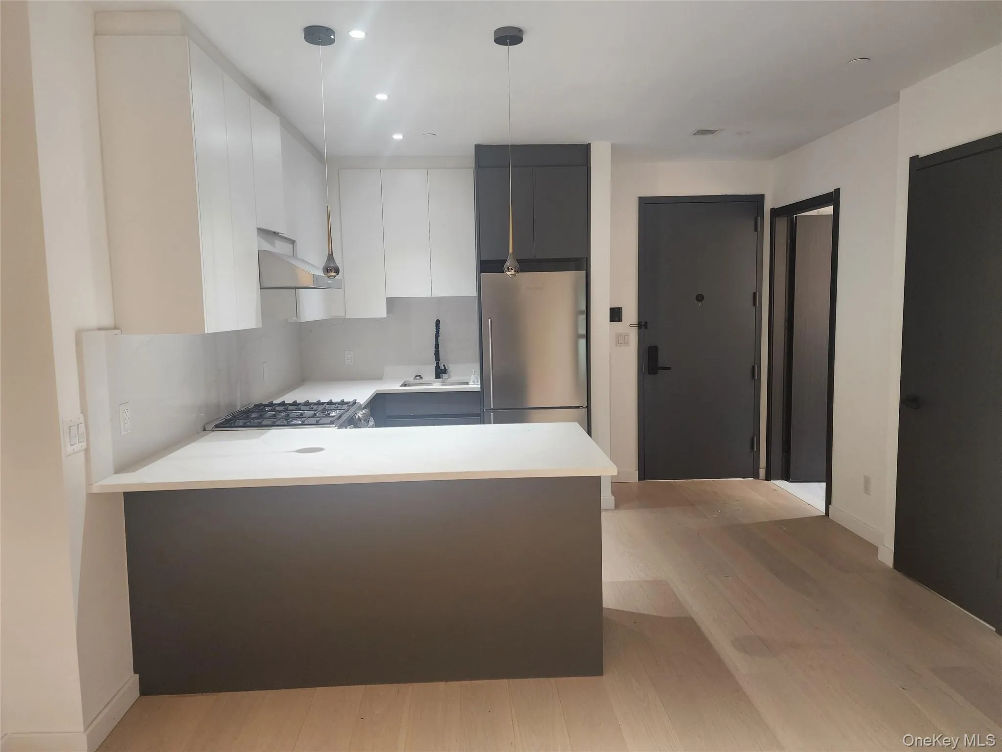 Contemporary kitchen featuring white cabinetry, a stainless steel refrigerator, and a gas range Contemporary kitchen featuring white cabinetry, a stainless steel refrigerator, and a gas range