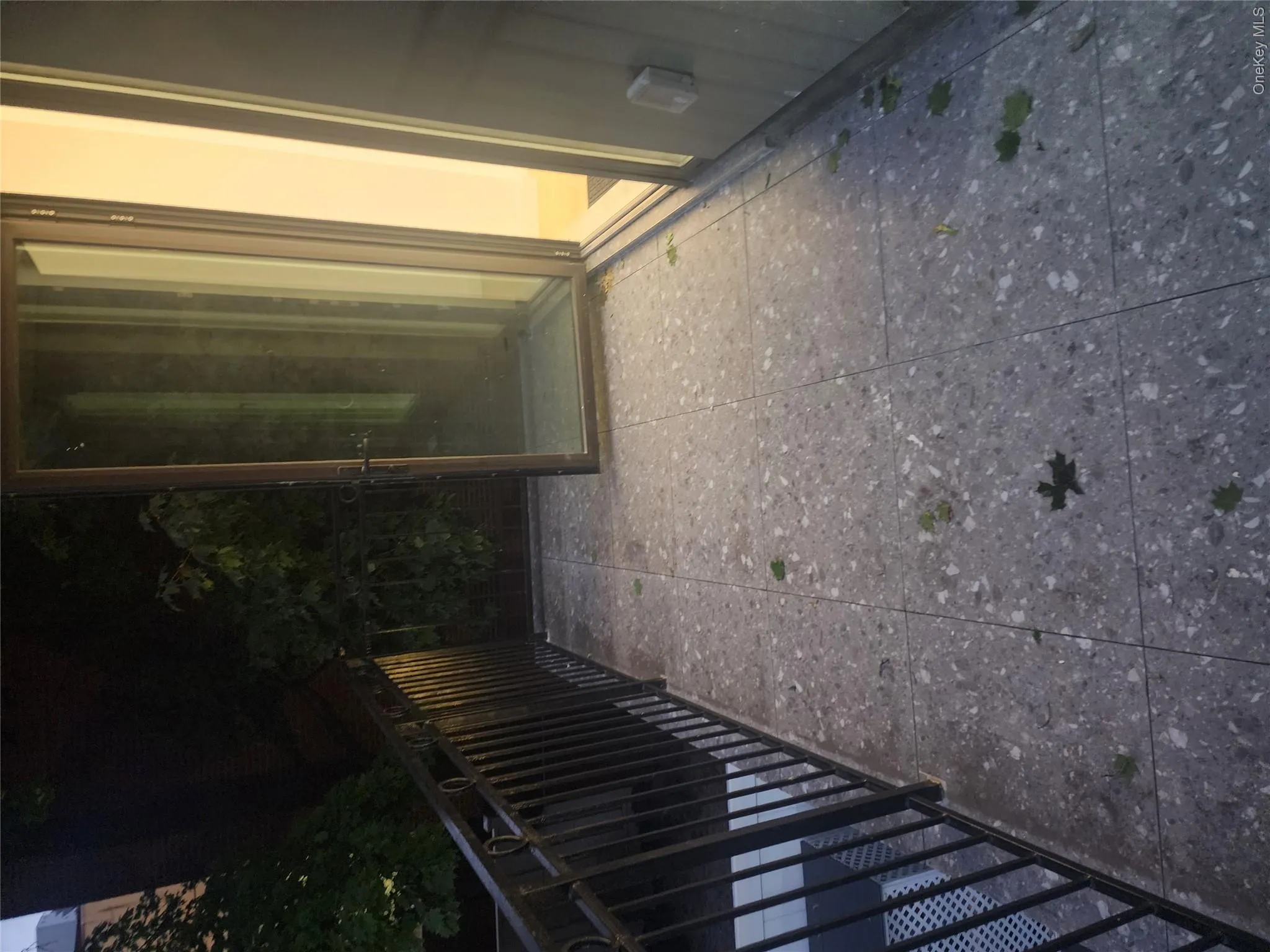 Outdoor balcony featuring large format tile flooring and a black metal railing Outdoor balcony featuring large format tile flooring and a black metal railing