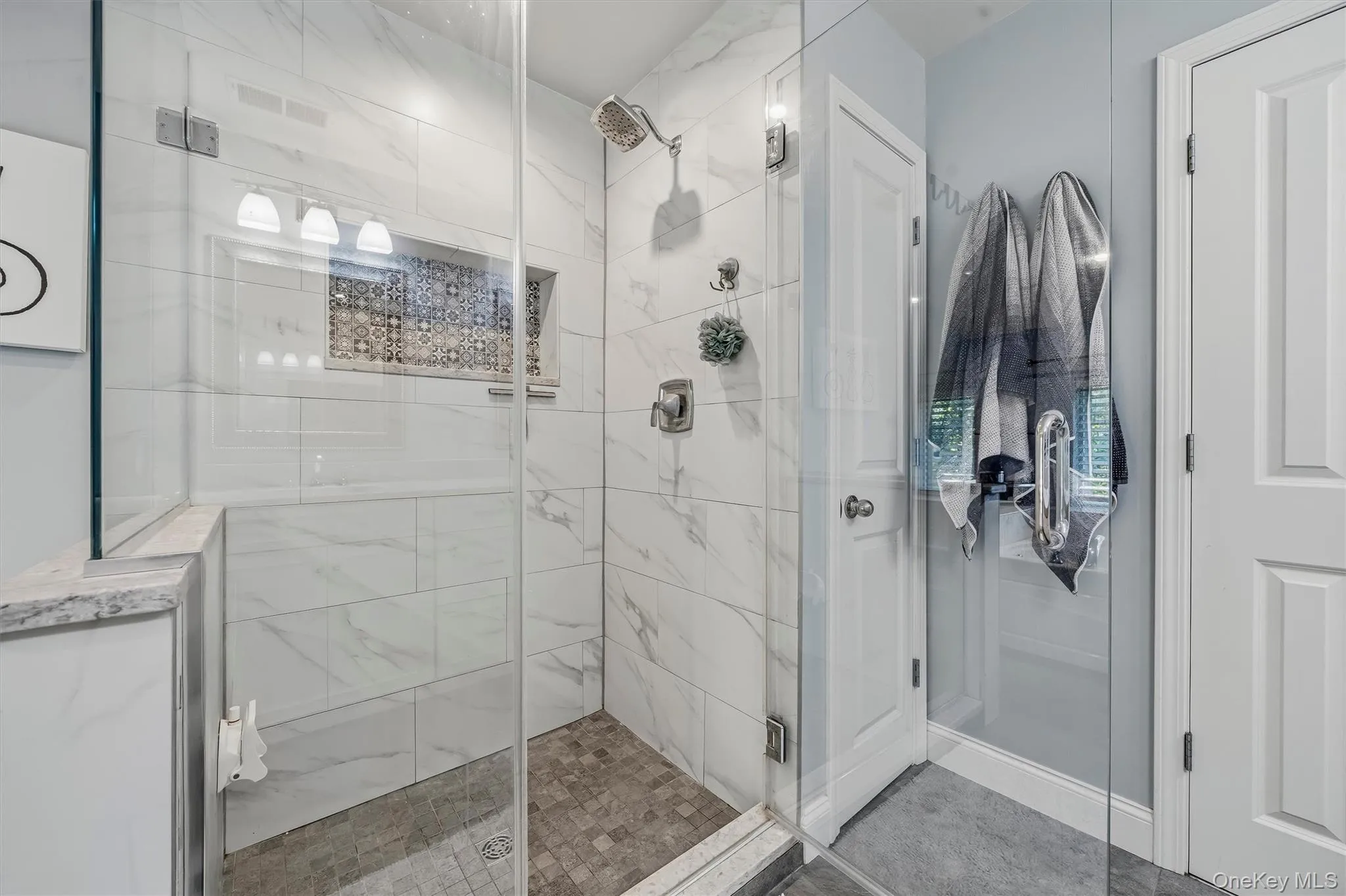 A seamless glass shower and a linen closet. A seamless glass shower and a linen closet.