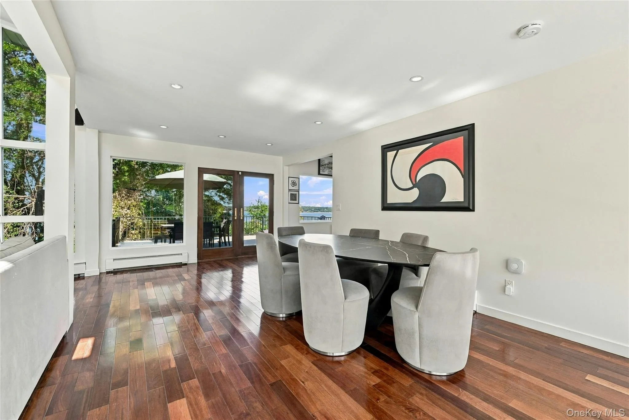 Dining room featuring hardwood flooring, recessed lighting, expansive glass windows, and glass-paneled double doors Dining room featuring hardwood flooring, recessed lighting, expansive glass windows, and glass-paneled double doors