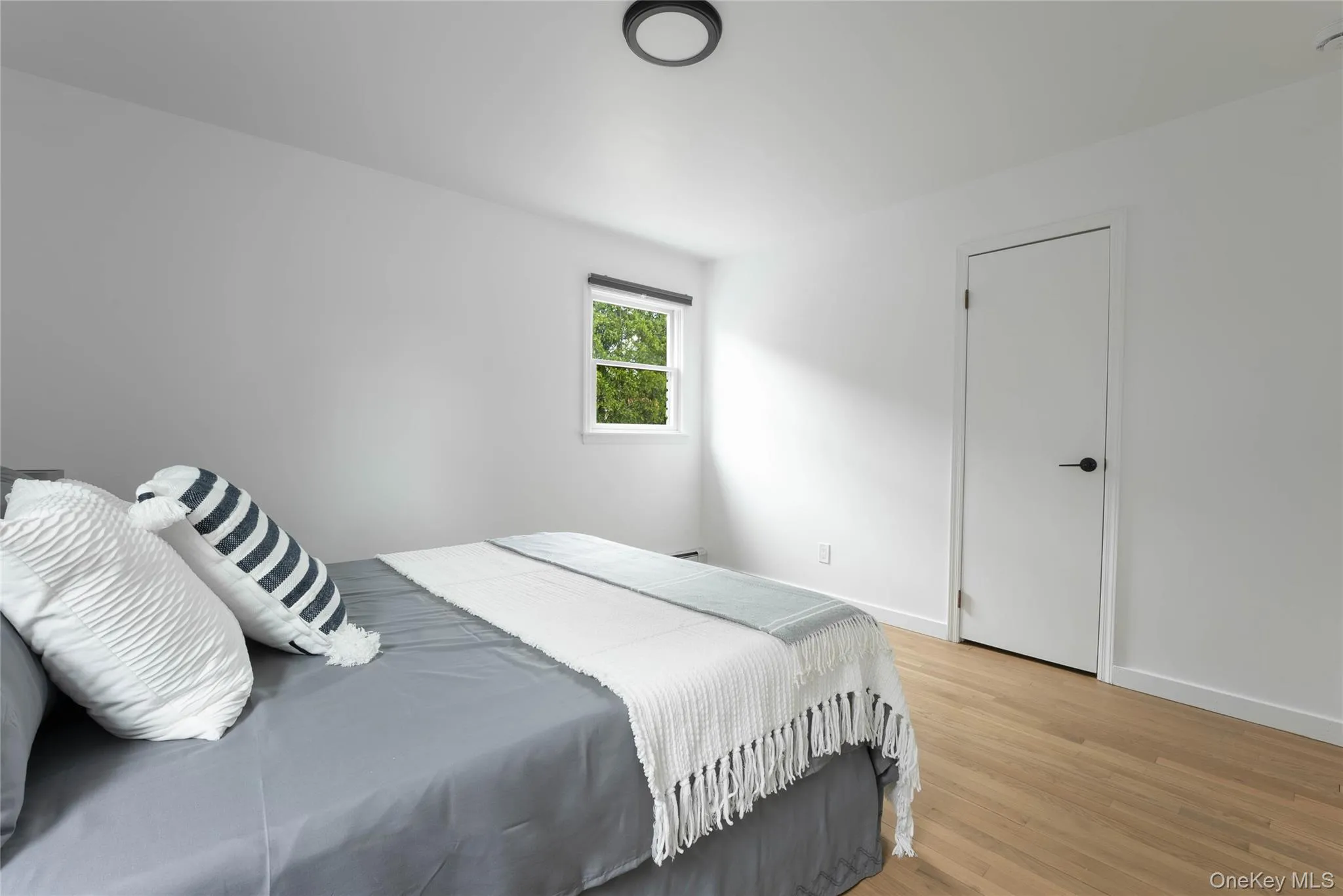 Bedroom featuring light wood-style floors and baseboards Bedroom featuring light wood-style floors and baseboards