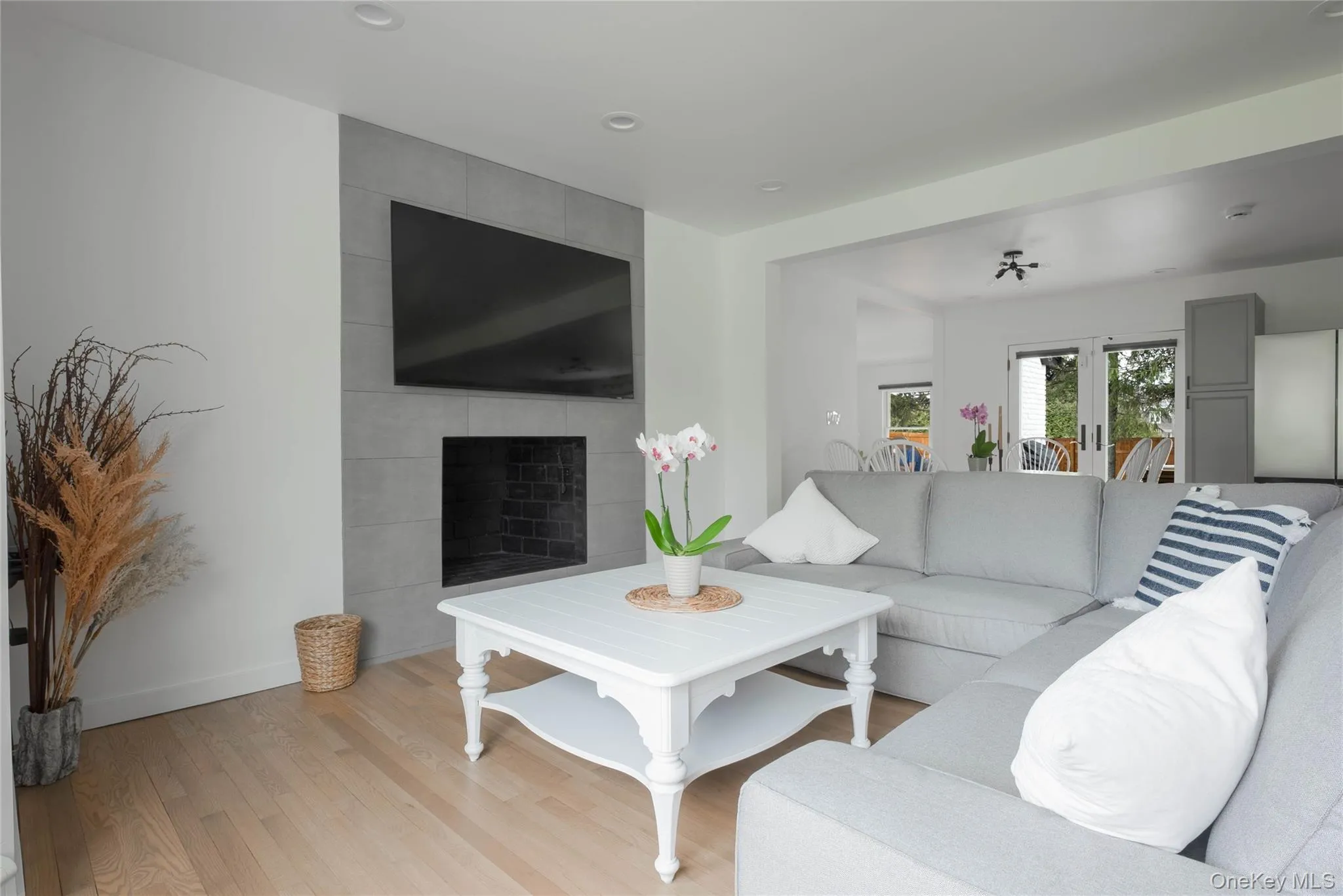 Living room with wood finished floors, a fireplace, recessed lighting, and french doors Living room with wood finished floors, a fireplace, recessed lighting, and french doors