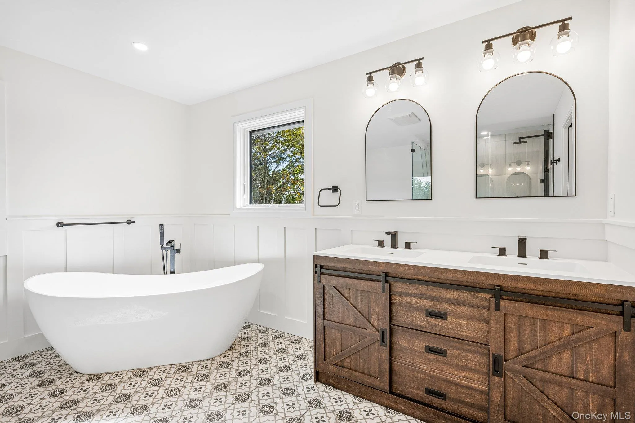 The primary bath: a freestanding soaking tub, patterned tile and a double vanity. Just as restorative, sunsets over the Great South Bay at the Blue Point Dock, less than half a mile away. The primary bath: a freestanding soaking tub, patterned tile and a double vanity. Just as restorative, sunsets over the Great South Bay at the Blue Point Dock, less than half a mile away.