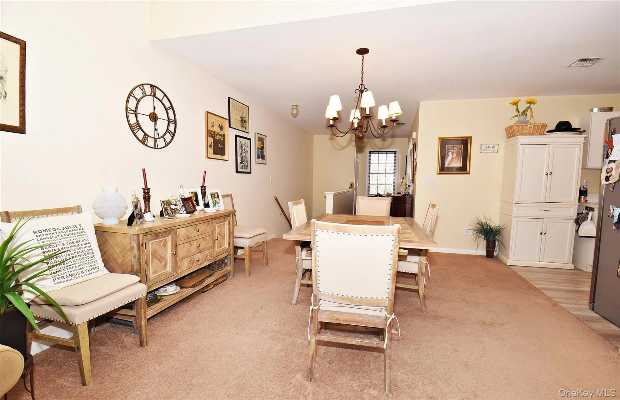 Dining area featuring baseboards, visible vents, a notable chandelier, and light colored carpet Dining area featuring baseboards, visible vents, a notable chandelier, and light colored carpet