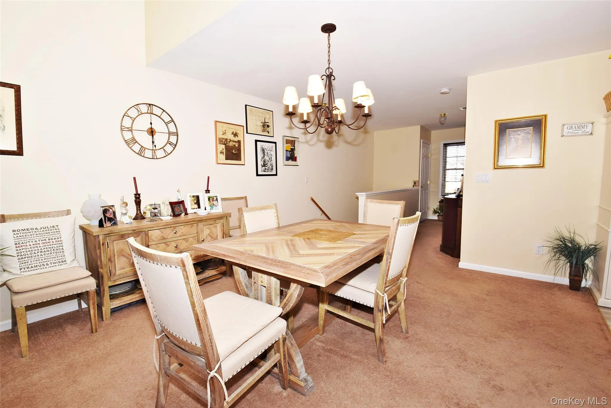 Dining room featuring light carpet, baseboards, and a notable chandelier Dining room featuring light carpet, baseboards, and a notable chandelier