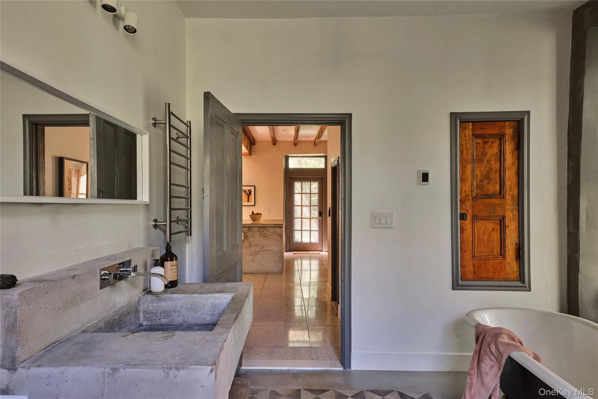 Bathroom featuring a freestanding tub, vanity, a towel warmer, and beam ceiling Bathroom featuring a freestanding tub, vanity, a towel warmer, and beam ceiling