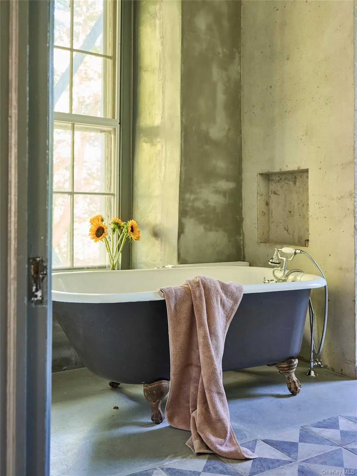 Bathroom featuring a freestanding tub and concrete floors Bathroom featuring a freestanding tub and concrete floors