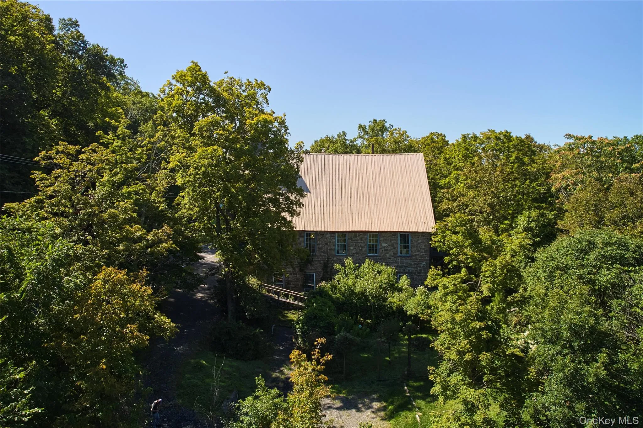Aerial view of property and surrounding area with a forest Aerial view of property and surrounding area with a forest